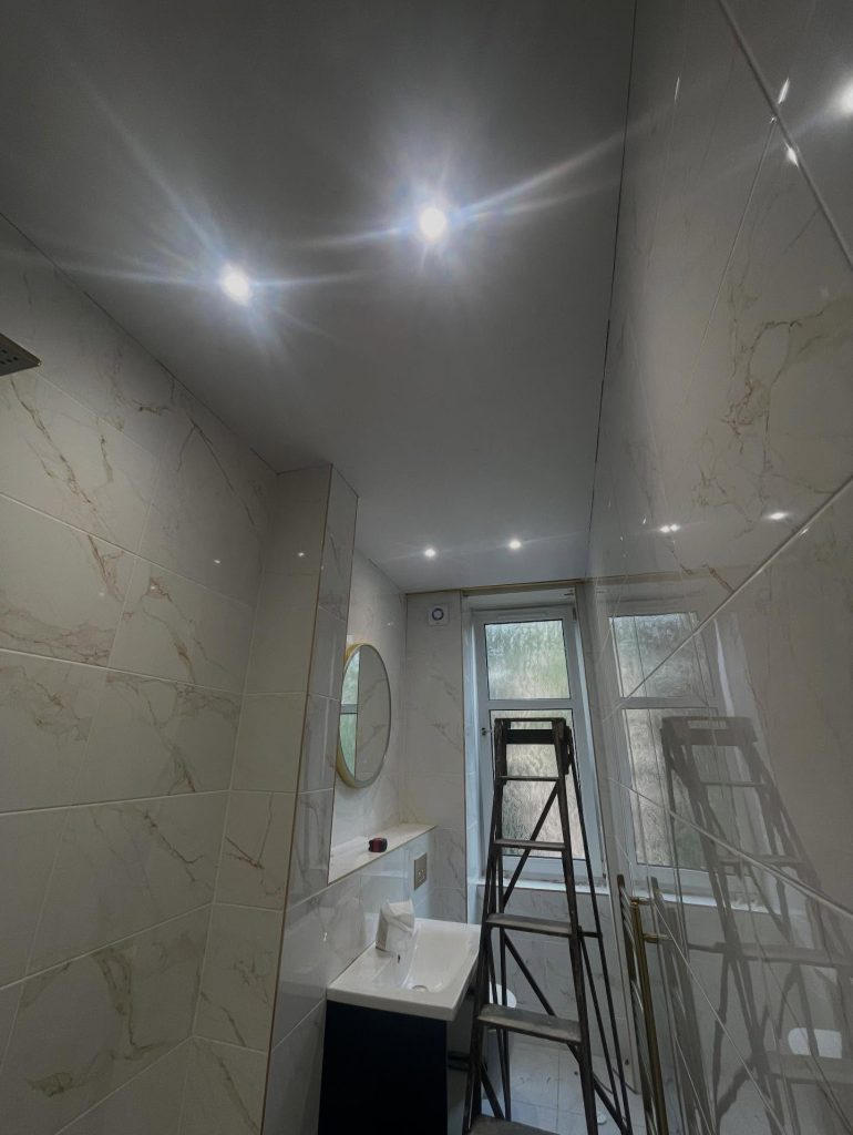Fire-rated downlights installed in a marble tiled bathroom in Glasgow